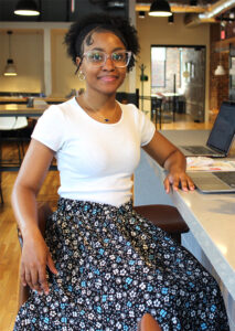 Makayla Williams sitting in the coworking kitchen at Gather Arts District