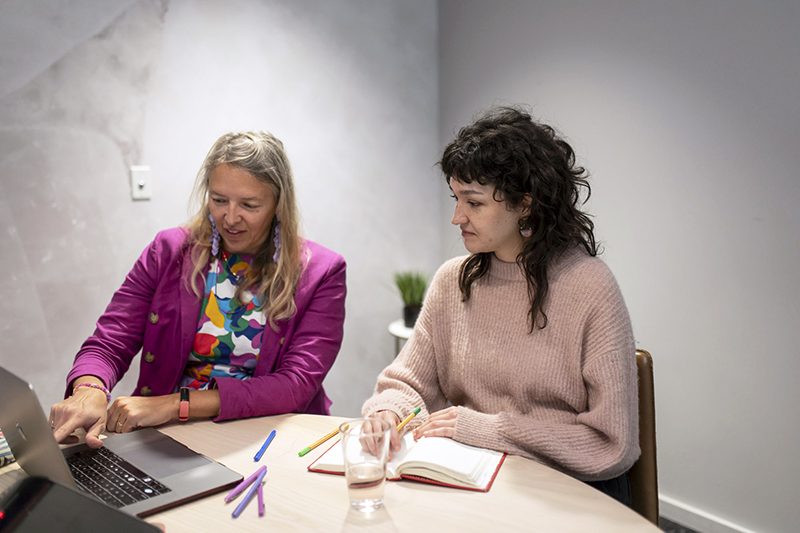 Jolinda Anderson and Jenna Marbukh discussing a web design project