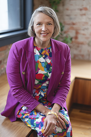 Jolinda Anderson, graphic and web designer and owner of Shapes & Colors, sitting in the open coworking space at Gather Arts District in downtown Richmond, VA